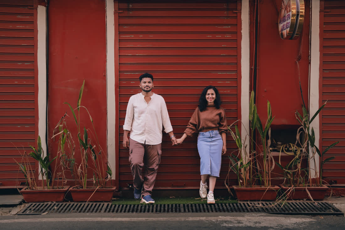 Rakshita and Rahul against a red wall